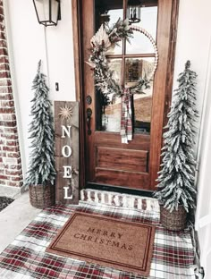 the front door is decorated for christmas with evergreens and pine cones on the mat