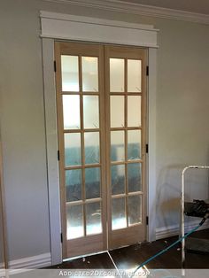 an empty room with double doors and hard wood flooring