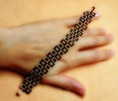 a woman's hand with a beaded bracelet on it