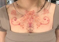 a woman with tattoos on her chest is looking at the camera