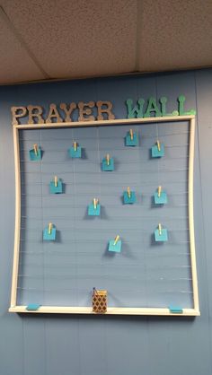 a bulletin board with magnets attached to it and the word prayer wall written on it