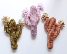 three crocheted objects are arranged on a white surface