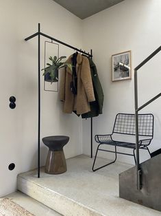 a chair and coat rack in a room