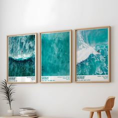 three framed surf posters hang on the wall above a table