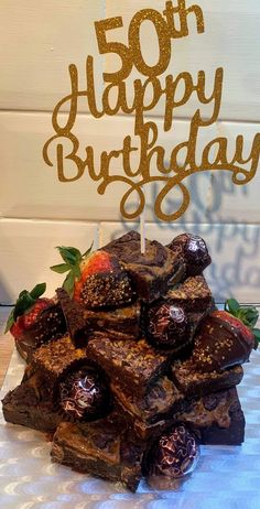 a birthday cake with strawberries and chocolates on the top that says, 50 happy birthday