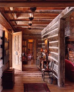 the inside of a log cabin with wood floors and walls, along with wooden furniture