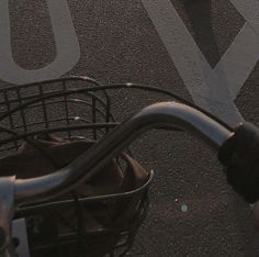 a person riding a bike with an umbrella in the back basket and another bicycle behind them