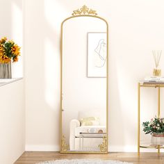 a mirror sitting on top of a wooden floor next to a white chair and table