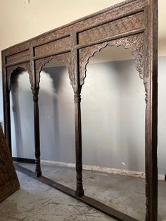 an ornate wooden table with marble flooring and walls in the background, is shown