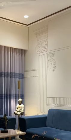 a living room with blue couches and a table in front of a curtained window