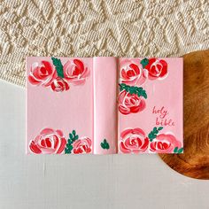 two pink cards with roses on them are next to a wooden board that says happy birthday