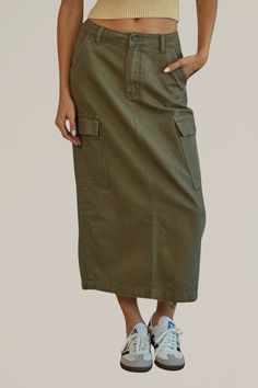 meet your new favorite midi skirt. this versatile olive cargo midi skirt can be worn multiple ways, making it a great investment for your closet. dress it up with strappy sandals and a tank top for an easy summer night out, or wear more casually with sneakers and your go-to favorite tee. the styling opportunities with this skirt are endless, making it one of our favorites! 100% cotton side pockets hand wash cold | hang to dry runs slightly small | if in between sizes, size up model is wearing a Long Cargo Skirt Outfit, Long Cargo Skirt, Cargo Skirt Outfit, Midi Skirt Green, Cargo Midi Skirt, Cotton Midi Skirt, Sandals Outfit, Ootd Ideas, Travel Outfits