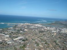 an aerial view of a city with the ocean in the back ground and blue sky