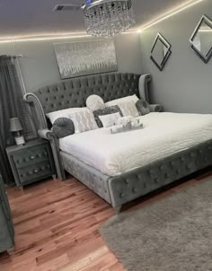 a large bed sitting in the middle of a bedroom next to a dresser and mirror