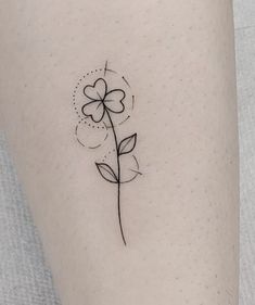 a small flower tattoo on the left side of the leg, it is black and white