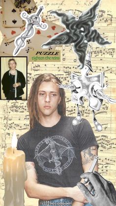 a man with long hair and tattoos holding a candle in front of sheet music notes