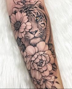 a tiger and flowers tattoo on the leg