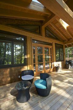 two wicker chairs sitting on top of a wooden floor next to a patio area