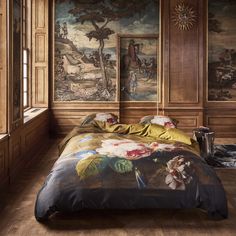 a large bed sitting inside of a bedroom next to a painting on the wall above it