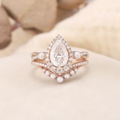 an engagement ring with a pear shaped diamond surrounded by pearls