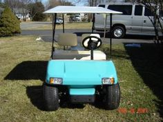 a blue golf cart parked in the grass