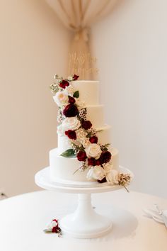 a white wedding cake with red and white flowers