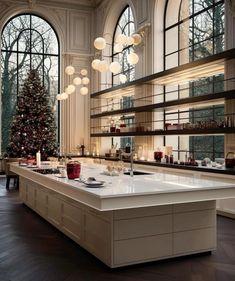 a large kitchen with lots of counter space and christmas tree in the window sill