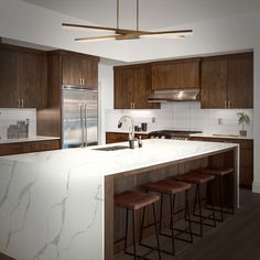 a large kitchen with marble counter tops and wooden stools in front of an island