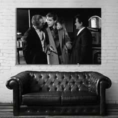 a black and white photo of three men talking to each other