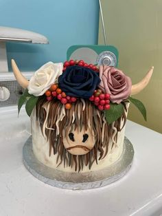 a cake decorated to look like a cow with horns and flowers on it's head