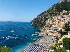 the beach is crowded with boats and buildings on it's sides, overlooking the ocean