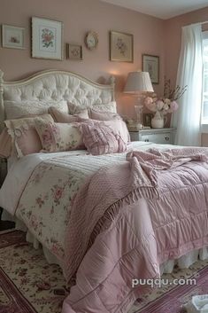 a bedroom with pink and white bedding, pictures on the wall and window sill