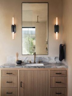 an image of a bathroom setting with vanity lights and mirrors on the wall above it