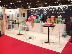 a booth at an event with tables and chairs