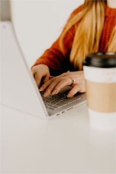 a woman typing on her laptop with a cup of coffee nearby