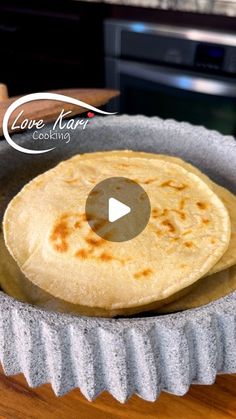 two tortillas sitting in a pan on top of a wooden table next to an oven