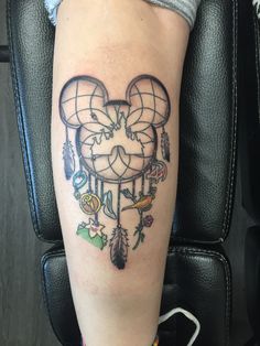 a woman's leg with a tattoo on it that has a heart shaped dream catcher