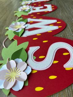 some paper flowers are laying on the floor next to red and yellow signs that say welcome