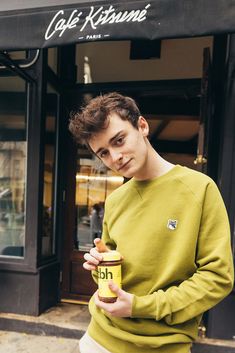 a young man is holding a can of coffee