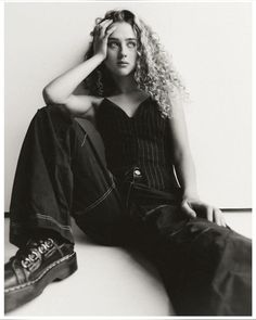 a black and white photo of a woman sitting on the floor