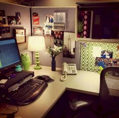 an office desk with a computer, phone and lamp