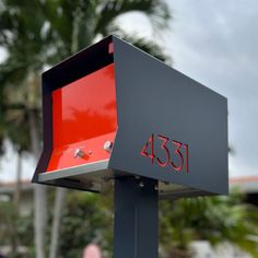 a red and black mailbox with the number 431 on it's side