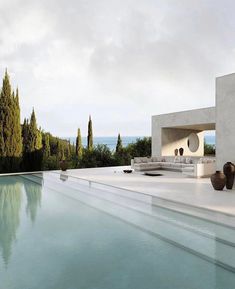 an outdoor pool with furniture and trees in the background