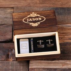 two pairs of cufflinks in a wooden box with personalized engraving on the front