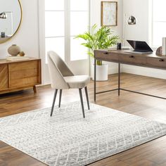 a living room area with a rug, table and chair on the hardwood flooring