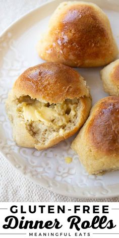 three biscuits on a white plate with butter and cheese in the middle one is cut in half