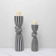 two black and white striped vases with candles