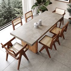 a dining room table with six chairs and a potted plant