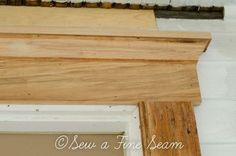 an unfinished piece of wood sitting on top of a white wall next to a window