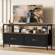 an entertainment center with drawers and a painting on the wall